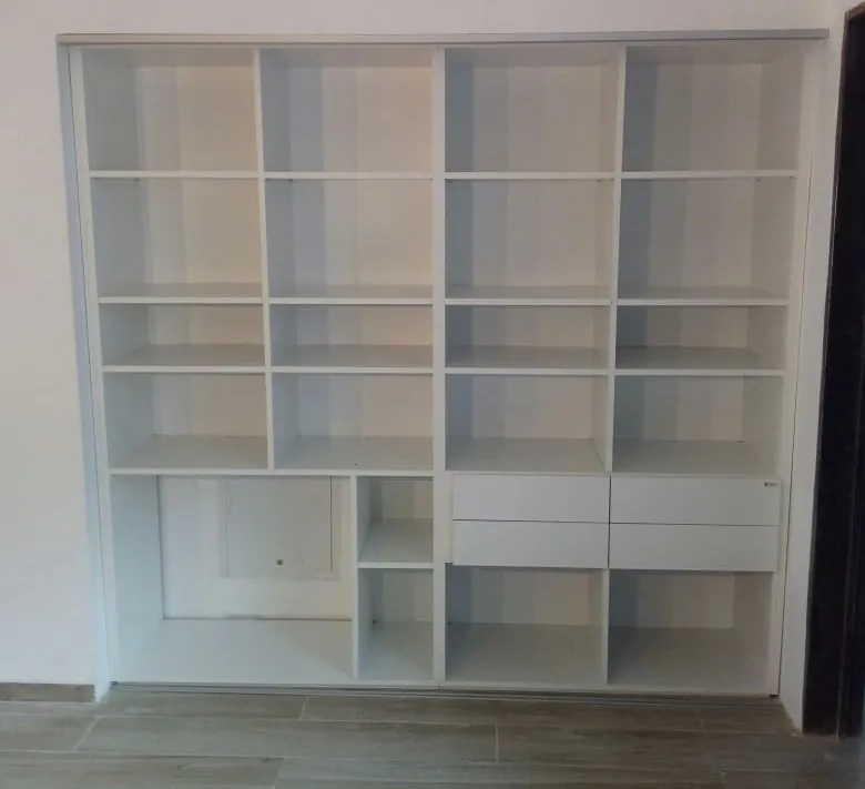 Mueble blanco a medida con estantes y cajones que llena un nicho de pared a pared y hasta el techo, fabricado en nuestro taller de General Roca