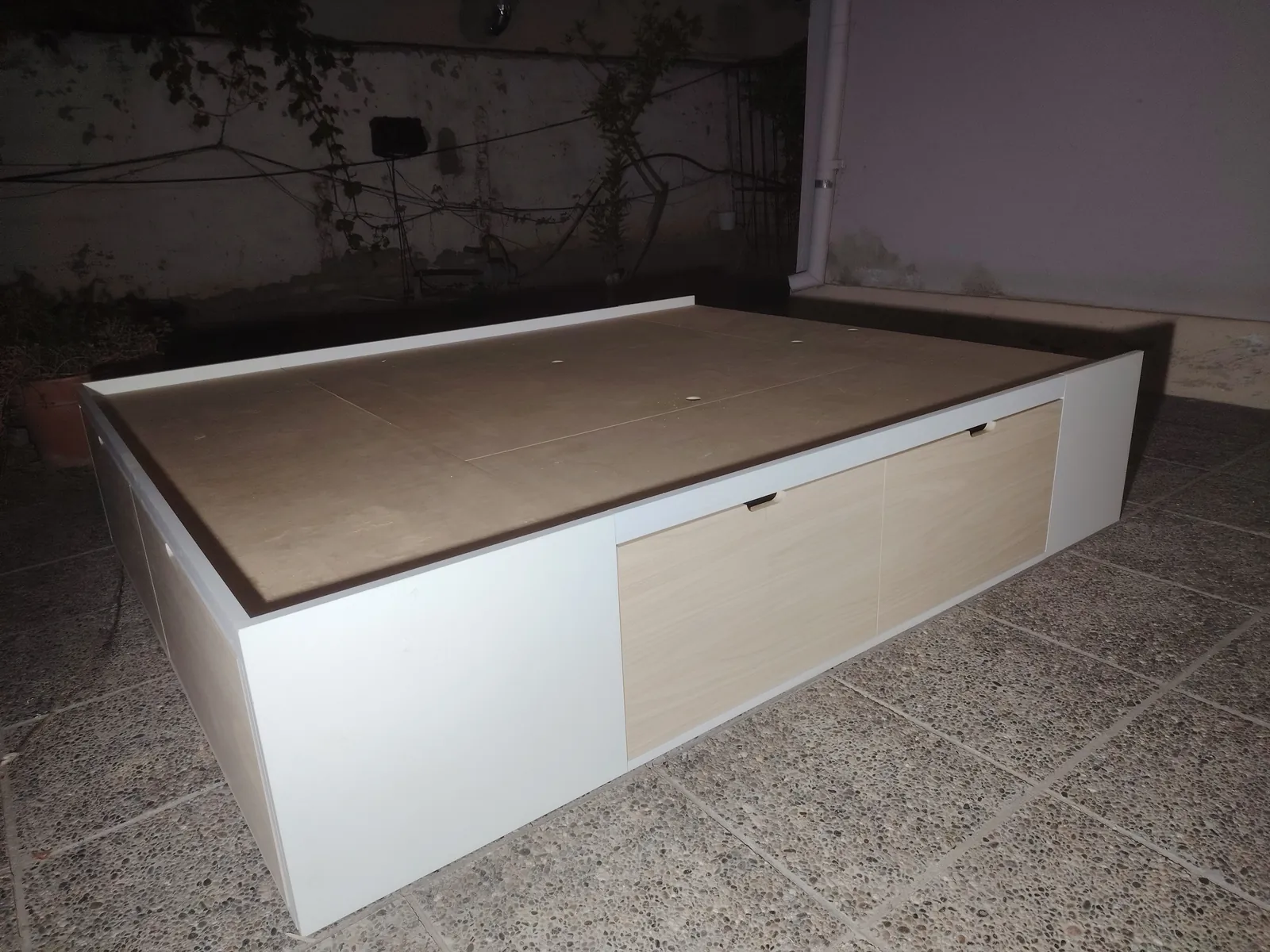 Base de cama a medida en blanco con frente lateral en tono madera claro y superficie plana para el colchón, fabricada en nuestro taller de General Roca