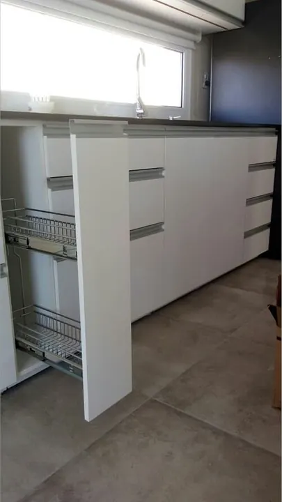 Columna extraíble angosta con canastos metálicos junto al bajo mesada, mueble de cocina a medida fabricado en nuestro taller de General Roca