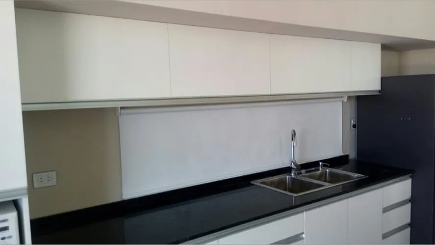 Cocina blanca a medida en melamina con mesada negra, bacha doble y alacenas, fabricada en nuestro taller de General Roca