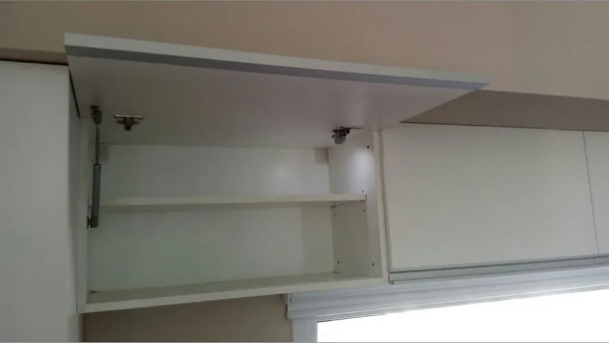 Alacena blanca con puerta rebatible abierta hacia arriba con pistones, mueble de cocina a medida fabricado en nuestro taller de General Roca