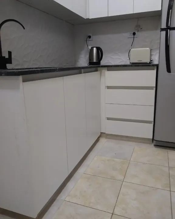 Bajo mesada blanco con perfil gola y cajones sin tiradores en una cocina a medida fabricada en nuestro taller de General Roca