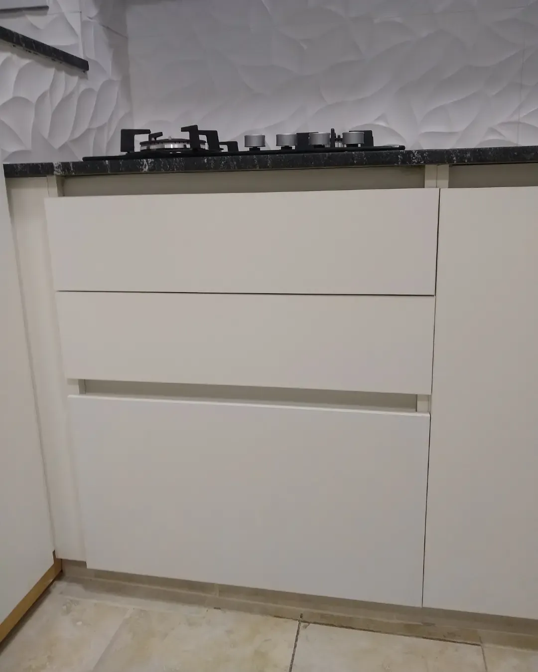 Cajones de cocina blanca con perfil gola, la ranura horizontal reemplaza al tirador, fabricados en nuestro taller de General Roca
