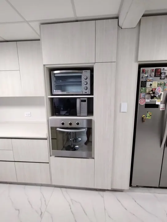 Columna de cocina a medida con horno eléctrico, microondas y horno empotrado junto a la heladera, fabricada en nuestro taller de General Roca