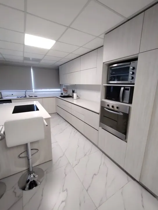 Cocina integral a medida con push open, columna de hornos e isla con banqueta, fabricada en nuestro taller de General Roca