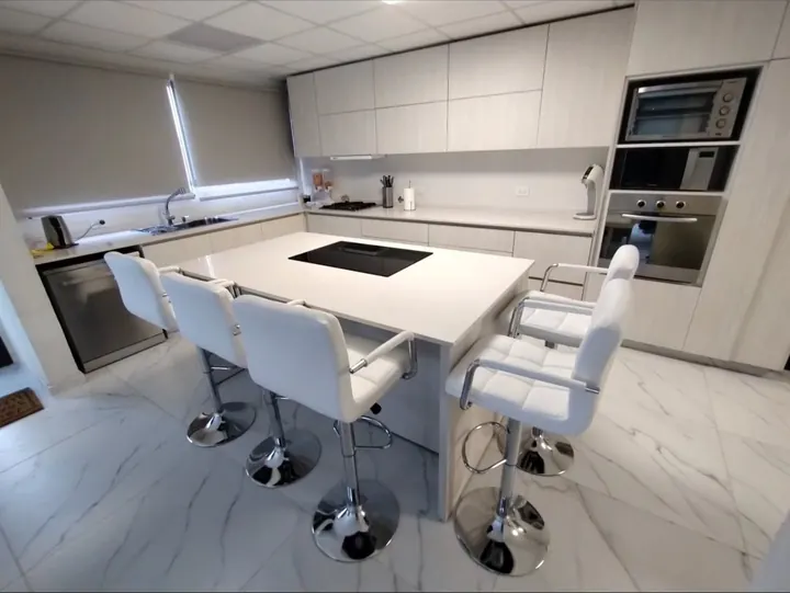 Cocina integral a medida en melamina Venezia con isla, anafe y banquetas, fabricada en nuestro taller de General Roca