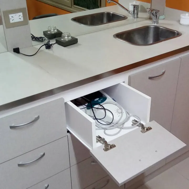 Frente rebatible abierto que deja ver un cajón interno para mangueras, mueble para consultorio odontológico fabricado a medida en nuestro taller de General Roca