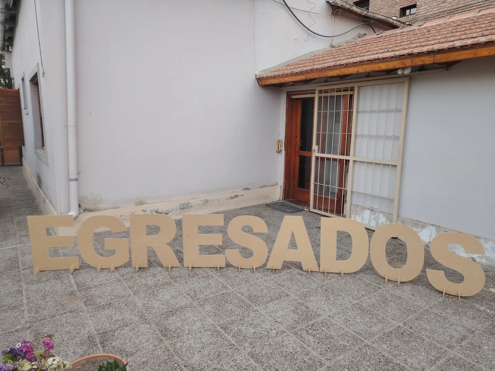 Letras corpóreas grandes EGRESADOS de pie con soportes en un patio, cortadas con router CNC en nuestro taller de General Roca