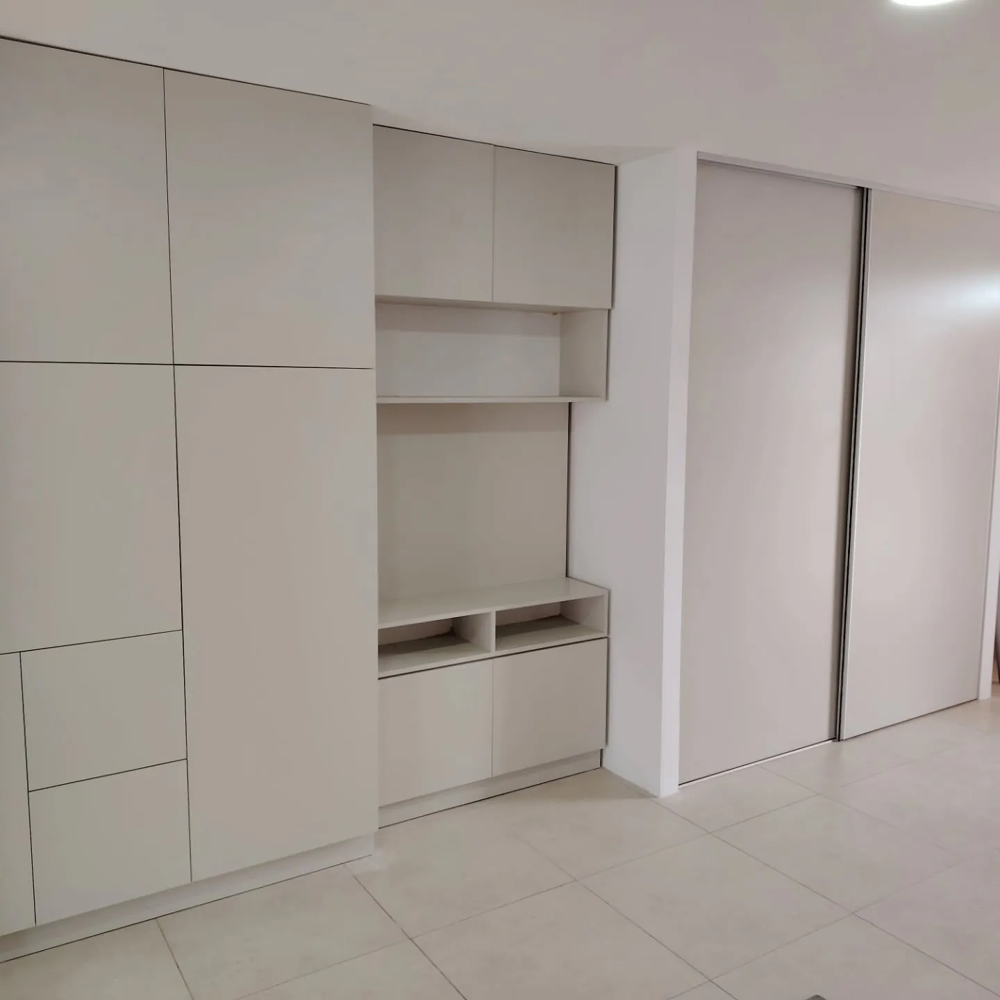 Mueble de guardado para garage con puertas altas y nicho de estantes abiertos en melamina blanca, fabricado a medida en nuestro taller de General Roca