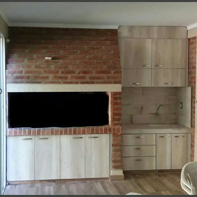 Muebles para quincho a medida en melamina Helsinki junto a una parrilla de ladrillo, fabricados en nuestro taller de General Roca