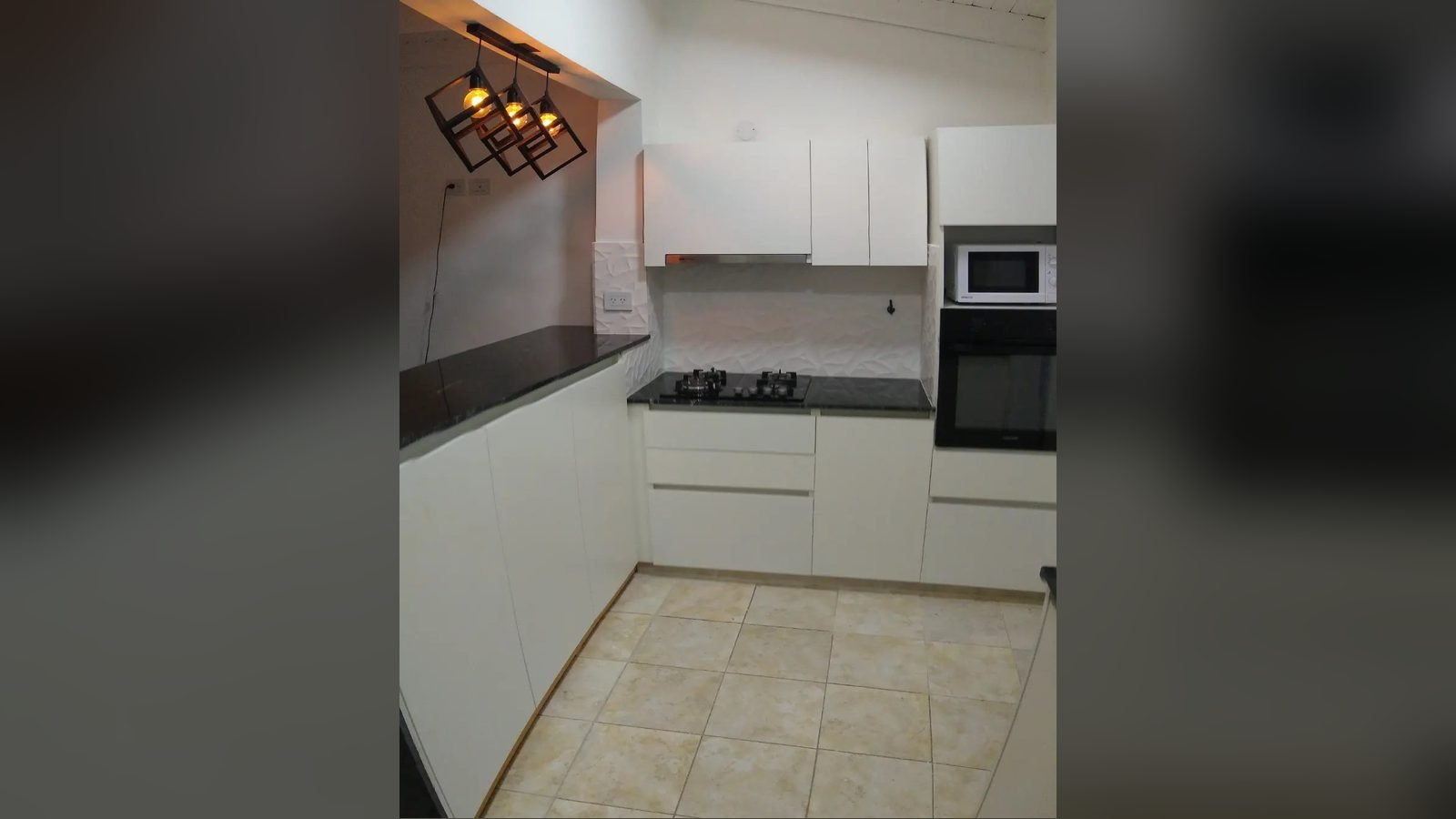 Cocina blanca sin tiradores con perfil gola, mesada negra y alacenas lisas, fabricada a medida en nuestro taller de General Roca