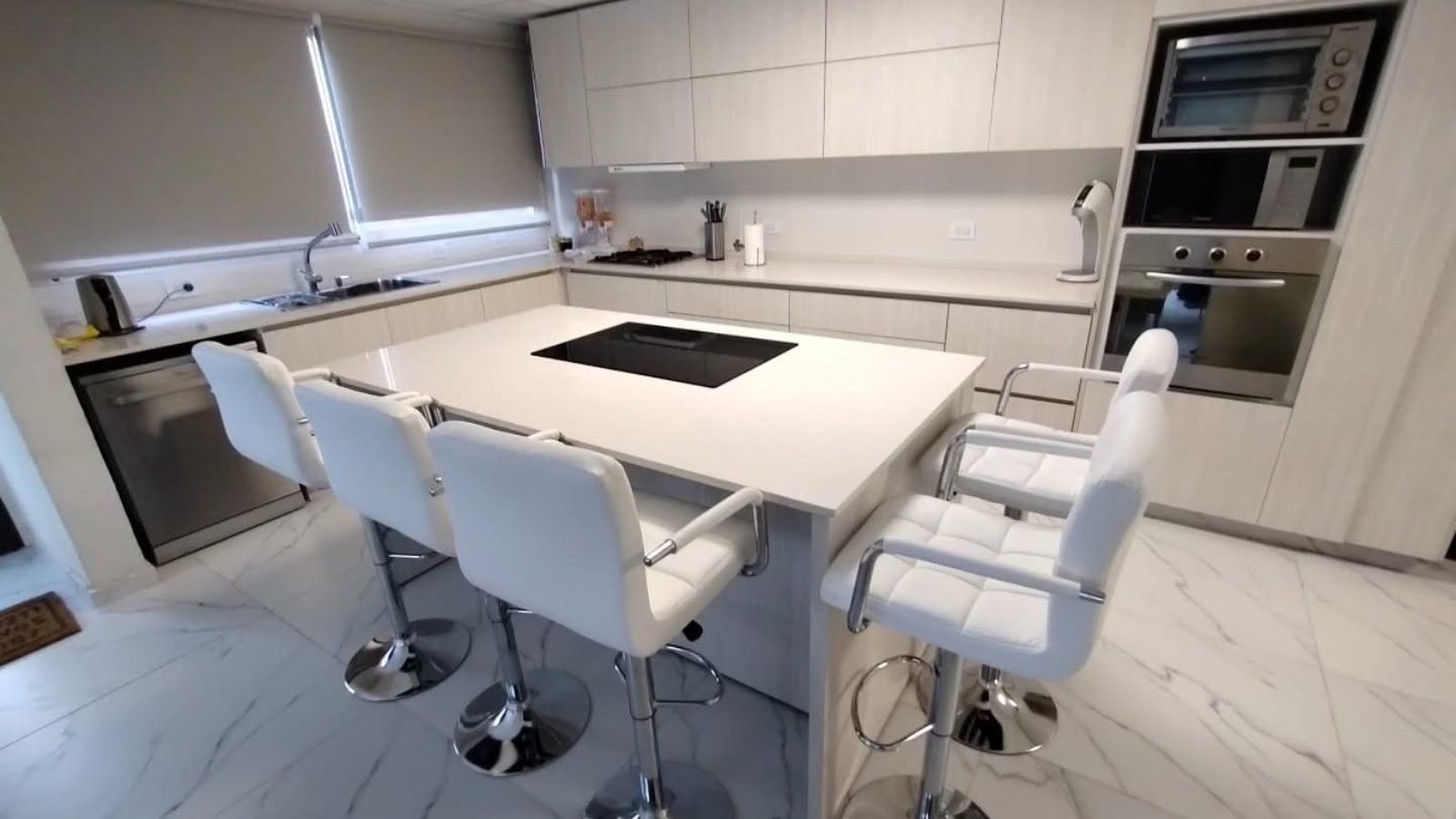 Cocina integral a medida en melamina Venezia con isla, anafe y banquetas, fabricada en nuestro taller de General Roca