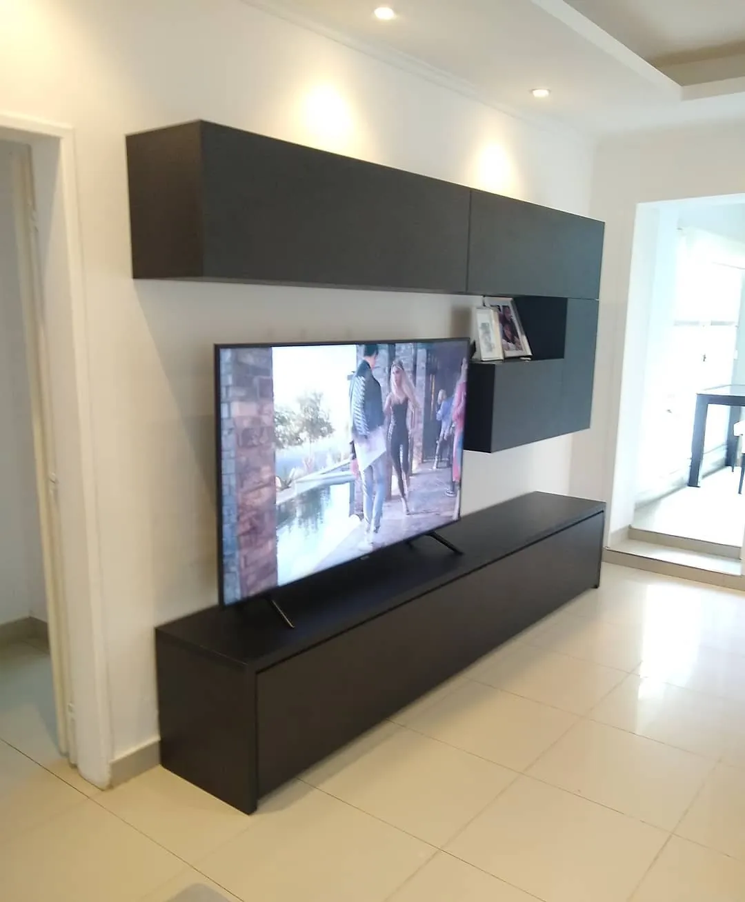 Rack de TV bajo y largo con alacenas flotantes en melamina Lino Negro, fabricado a medida en nuestro taller de General Roca