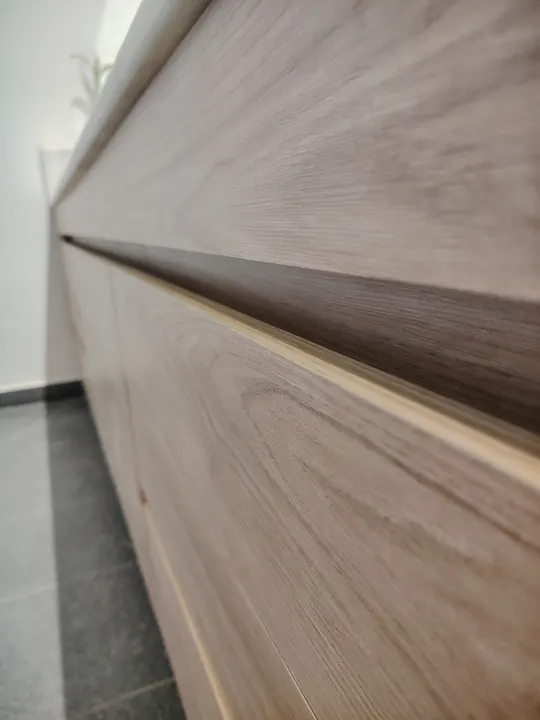 Detalle de frentes de vanitory en tono madera con ranura horizontal que hace de tirador, fabricado en nuestro taller de General Roca